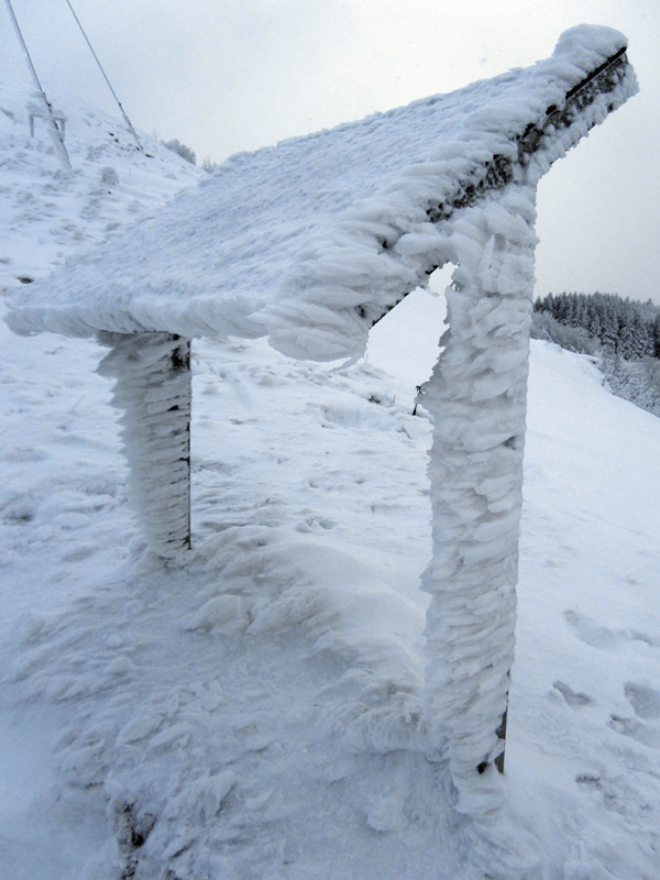 Schneeskulpturen an Hinweisschild
